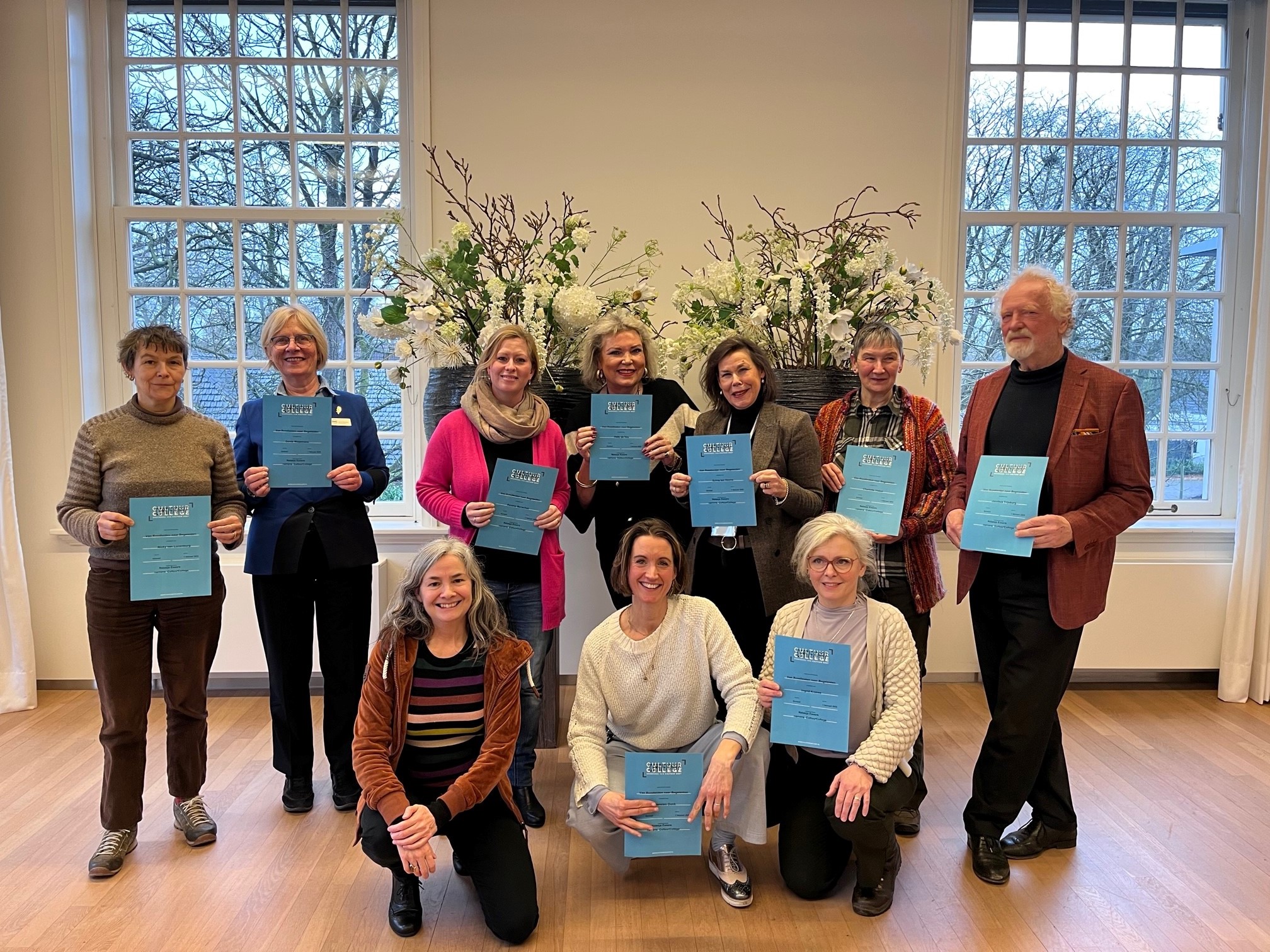 Geslaagde deelnemers met hun diploma poseren